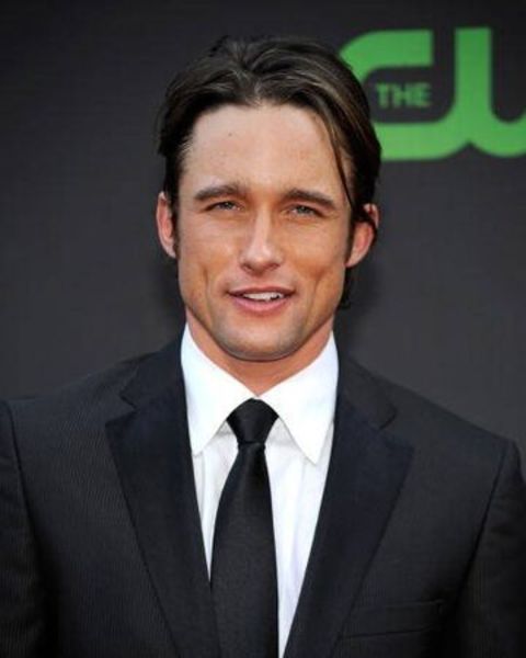 Jay Kenneth poses a picture in a dark black suit.